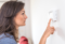 Woman adjusting thermostat